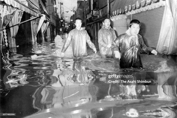3 men evacuate inundated areas, Typhoon Judy, Tokyo, 12 September 1982, by Asahi Shimbun via Getty Images.