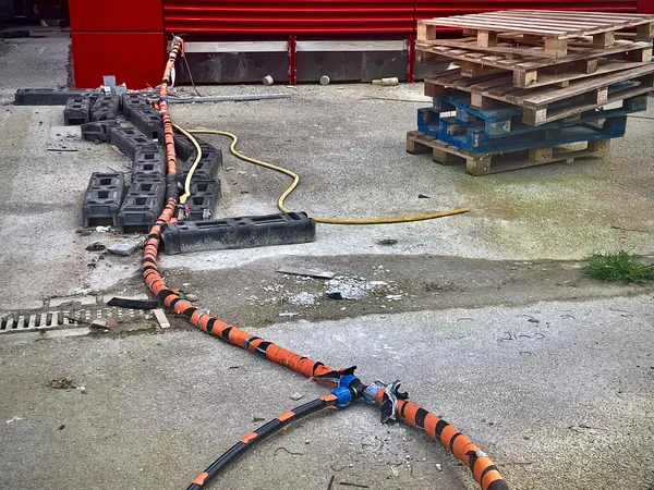 A working site with a wooden pallet and a orange and blue cable, in Belval, Luxembourg.