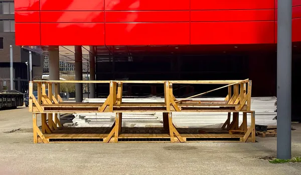 A working site with a wooden pallet against a red building, in Belval, Luxembourg.