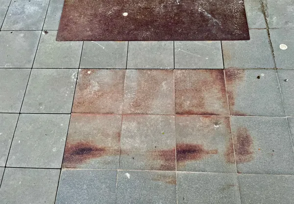 Rust on floor tiles on the pavement, in Luxembourg.